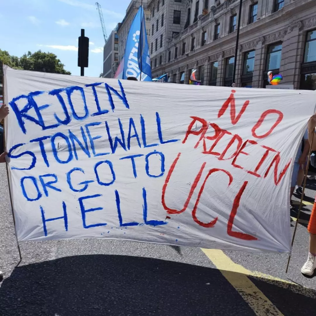 A photo of a very large banner which says “Rejoin Stonewall or go to hell. No Pride in UCL.”
