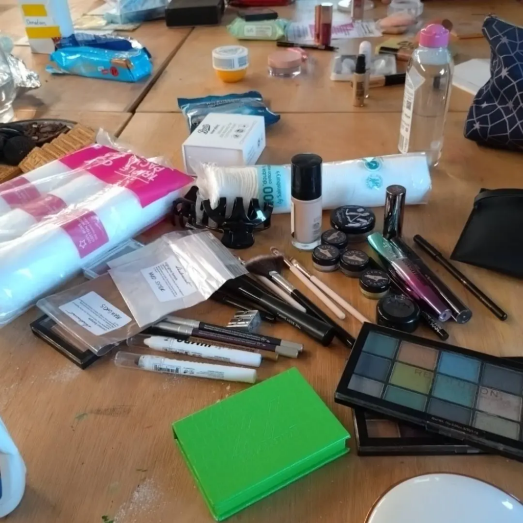 Upclose photograph of some of the products on the table including eyeshadow pallets, makeup brushes and other products.
