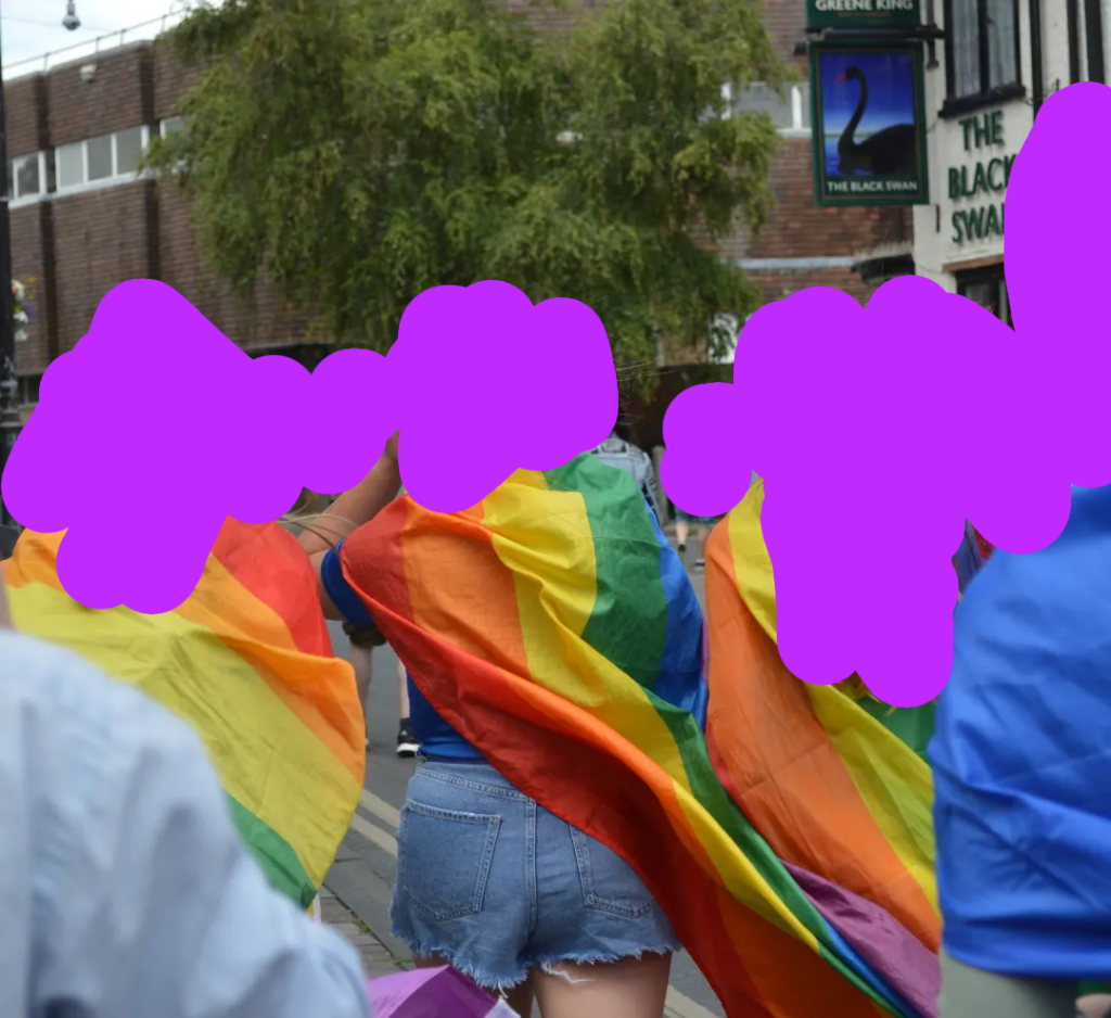 a group of people wearing rainbow flags on their backs